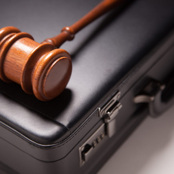 Gavel and Black Briefcase on Gradated Background with Selective Focus - Business Law Concept.
