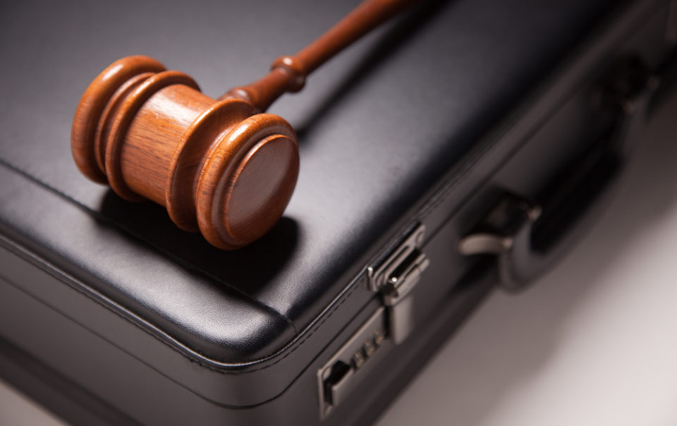 Gavel and Black Briefcase on Gradated Background with Selective Focus - Business Law Concept.